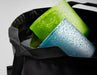Close-up image of a black washbasin bag containing a wet blue and a wet green cup with water droplets, against a neutral background.