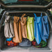 Image of multiple Gear Aid microfiber towels hanging to dry inside an open vehicle trunk, assorted fabric colors in outdoor travel use, rear lifestyle view.