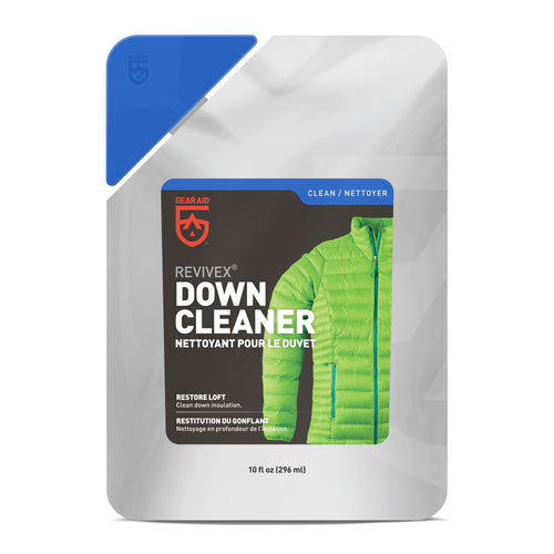 Image of Gear Aid Revivex Down Cleaner pouch, resealable silver packaging with black and blue label, featuring green down jacket graphic and product branding, front-facing view on white background.