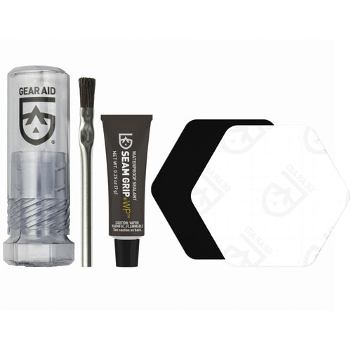 Image of Gear Aid Seam Grip WP Field Repair Kit components, including clear storage case, brush applicator, adhesive tube, and repair patches, laid out side by side on white background.