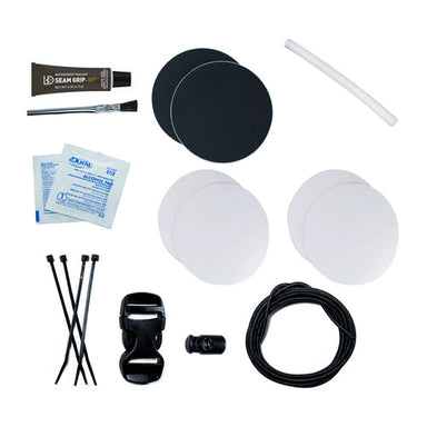 Image of Gear Aid Tenacious Tape Camp Repair Kit contents laid out flat, including adhesive patches, alcohol wipes, seam grip adhesive, cord, buckles, cable ties, and applicator on a white background.