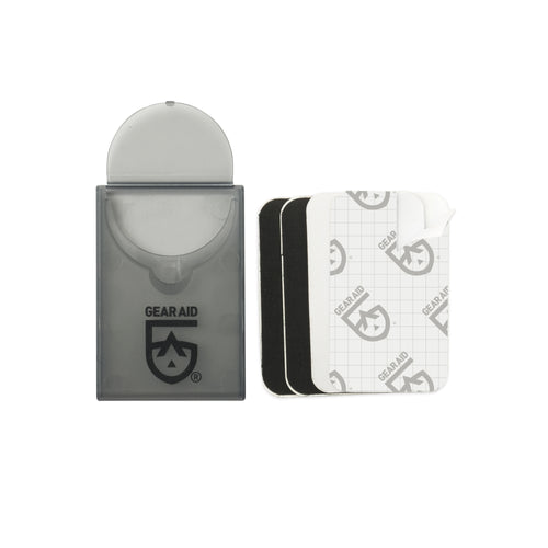 Image of Gear Aid Tenacious Tape mini repair patches with compact pocket case and stacked pre-cut black and clear patches, front-facing product view on white background.