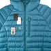Image of Gear Aid Tenacious Tape Mini Patches shown repairing a tear on a blue down jacket, with compact patch case and pre-cut patches displayed, front view on white background.