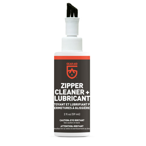 Image of Gear Aid zipper cleaner and lubricant bottle with integrated brush applicator, black label with orange accents, 2 fl oz size, upright front view on white background.