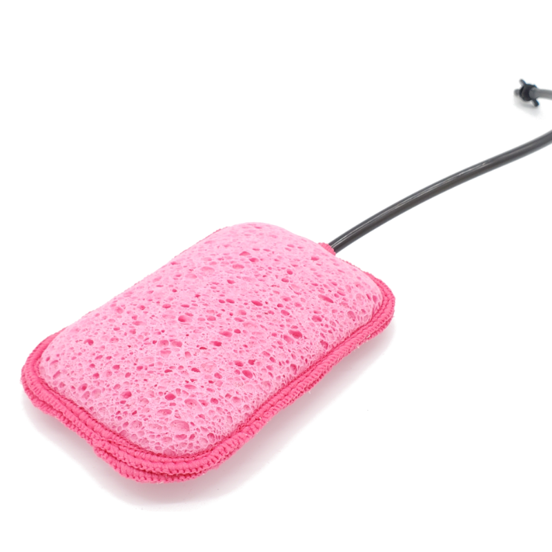 Image of Geyser Systems pink scrub sponge attachment with porous texture and black hose connection, angled close-up view on white background.