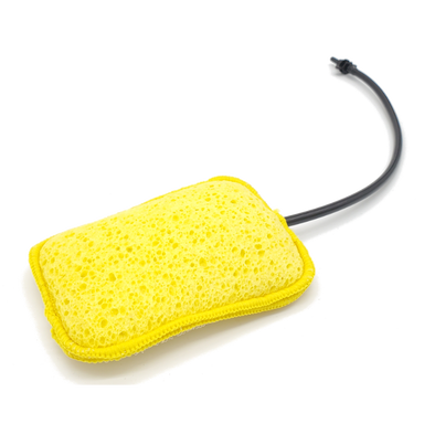 Image of Geyser Systems yellow scrub sponge attachment with porous texture and black hose connection, angled front view on white background.