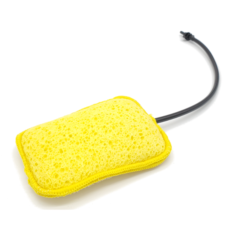 Image of Geyser Systems yellow scrub sponge attachment with porous texture and black hose connection, angled front view on white background.