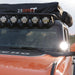 Angled front view of an orange and black off-road vehicle with a "23ZERO" roof top tent, a row of five round LED lights on the roof rack, and a single LED light mounted on the side mirror