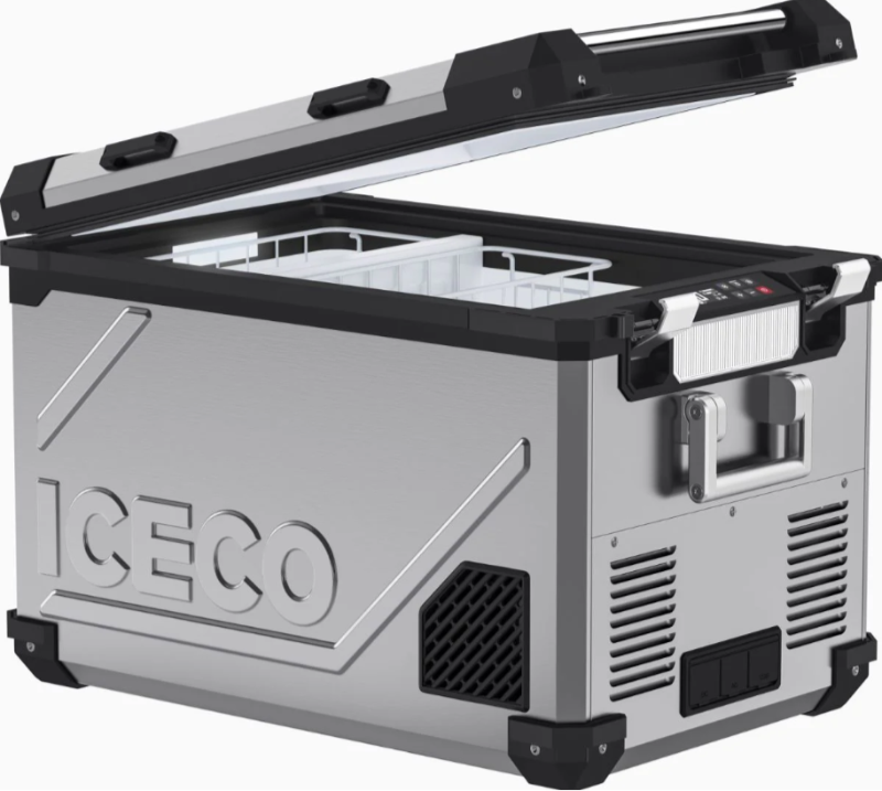 An image of a silver ICECO portable refrigerator/freezer with its lid partially open, revealing a white interior basket. The cooler features black accents on the top edge and corners, a textured design on the side with the ICECO logo, a control panel, and sturdy handles. It is shown from an angled front and side view