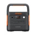 Image of Jackery Explorer 2000 portable power station with integrated handle, black and orange casing, front control panel with LCD display, AC and USB ports, straight-on front view on white background.