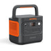 Image of Jackery Explorer 2000 portable power station with integrated carry handle, black and orange casing, front control panel with LCD display and multiple ports, angled front and side view on white background.