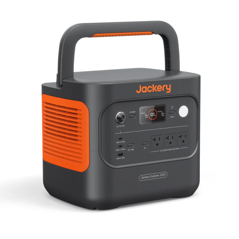 Image of Jackery Explorer 2000 portable power station with integrated carry handle, black and orange casing, front control panel with LCD display and multiple ports, angled front and side view on white background.