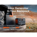Image of a Jackery portable power station and foldable solar panel placed on a vehicle tailgate during outdoor travel, black and gray units with orange accents, angled front view in a desert landscape setting.