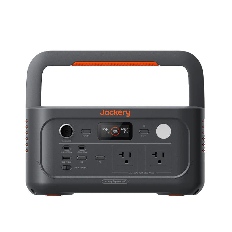 Image of a Jackery Explorer 600 portable power station with integrated handle, black and gray body with orange accents and front control panel, straight-on front view on white background.