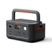 Image of a Jackery Explorer 600 portable power station with integrated handle, black and gray housing with orange accents and side ventilation, angled front and side view on white background.