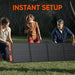 Image of a Jackery portable foldable solar panel being set up outdoors by two adults and a child on grass, black photovoltaic panels with orange accents, front view in a natural outdoor setting.