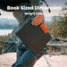 Image of Jackery SolarSaga 40W Mini portable solar panel shown being carried outdoors, black foldable panel with orange logo and size measurements displayed, angled front view in outdoor nature setting.
