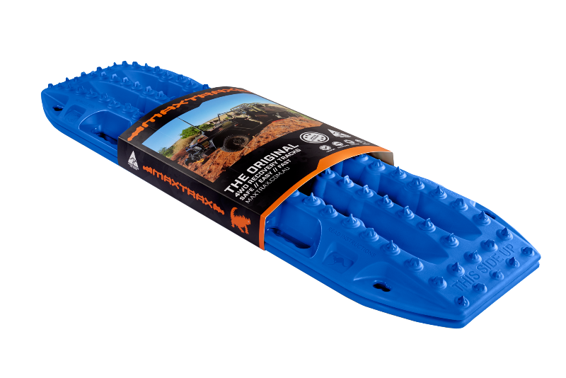 Image of a blue Maxtrax recovery board, wrapped with its product packaging displaying branding and an off-road vehicle, angled on a light gray background.