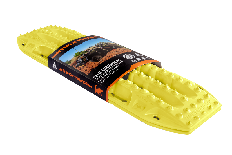 Image of blaze yellow Maxtrax recovery board, wrapped with its product packaging displaying branding and an off-road vehicle, angled on a light gray background.