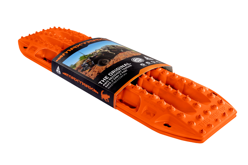 Image of an orange Maxtrax recovery board, wrapped with its product packaging displaying branding and an off-road vehicle, angled on a light gray background.