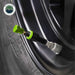 Image of an Up Down Air tire deflator with a green cap and black body, attached to a tire valve stem on a black vehicle rim, on a white background with the "Overland Vehicle Systems" logo.