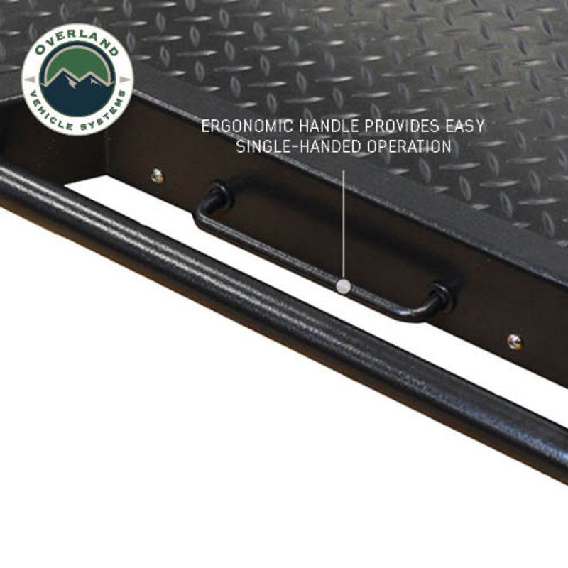Image of Overland Vehicle Systems truck bed extension featuring an ergonomic handle, highlighting its easy single-handed operation, close-up view on a diamond plate surface