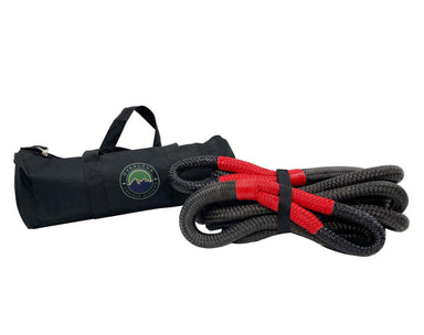 Image of Overland Vehicle Systems kinetic recovery rope with red reinforced loops and black braided synthetic rope, displayed alongside branded black storage bag, angled front view on white background.