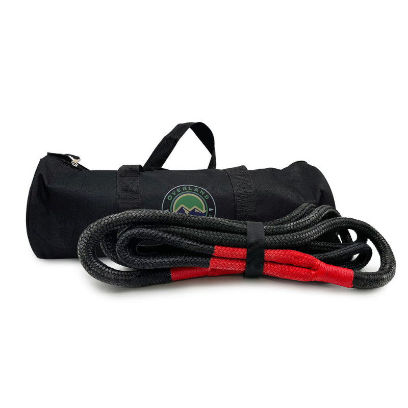 Image of Overland Vehicle Systems kinetic recovery rope coiled with red protective sleeves and black storage bag with carry handles, black braided synthetic rope shown in front angled view on white background.