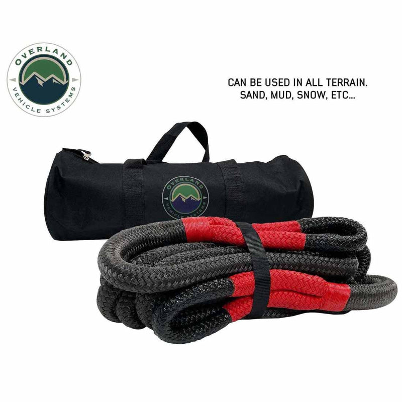 Image of Overland Vehicle Systems kinetic recovery rope with red reinforced loops and black braided synthetic rope, shown with branded black storage bag and terrain use callout, front angled view on white background.