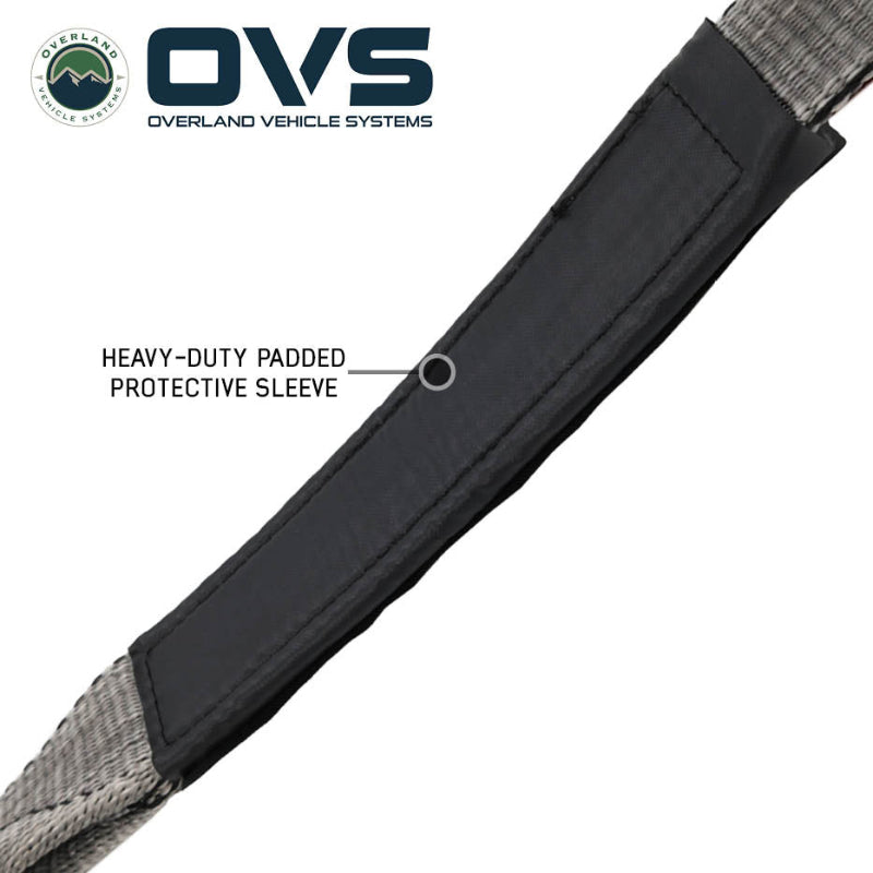 Image of OVS Brute Recovery Tow Strap detail showing a heavy-duty black padded protective sleeve over gray synthetic webbing, close-up angled view on a white background.