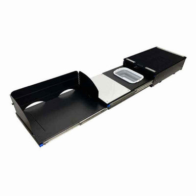 Image of a black camp kitchen cargo box fully extended, revealing a sink basin, a utensil drawer, and an area for a camp stove. The cargo box is on a white background, angled front and side view