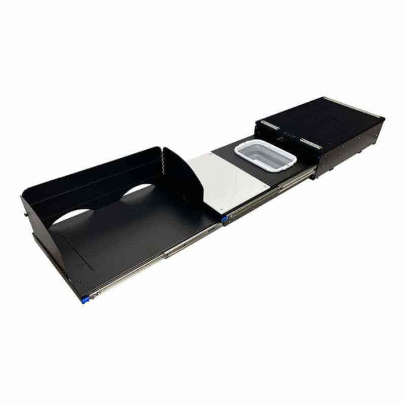 Image of a black camp kitchen cargo box fully extended, revealing a sink basin, a utensil drawer, and an area for a camp stove. The cargo box is on a white background, angled front and side view