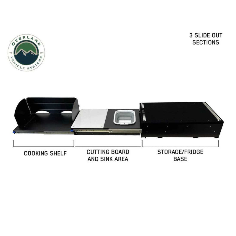 Image of the camp kitchen cargo box fully extended, highlighting the three slide-out sections. The sections are labeled as a cooking shelf, a cutting board and sink area, and a storage/fridge base