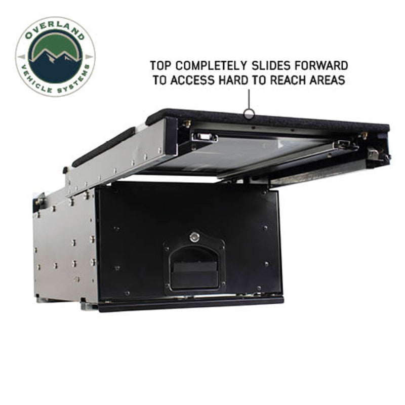 Image of an OVS Cargo Box with its top storage tray slid forward to demonstrate access to the storage area beneath. The black and silver storage system for vehicles is shown from a side view on a white background