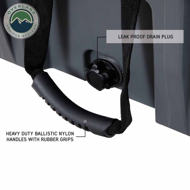 Image of dark gray overland dry storage box side detail showing leak-proof drain plug and heavy-duty ballistic nylon handle with rubber grip, close-up angled view on white background.