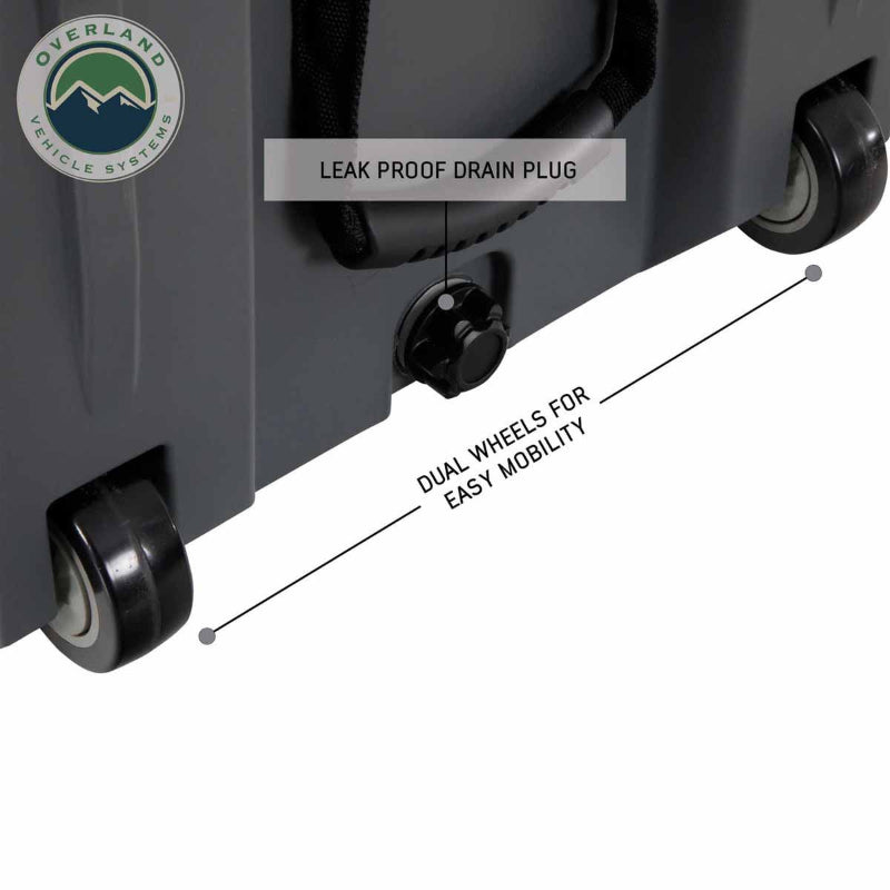 Image of large hard-shell storage dry box bottom detail showing leak-proof drain plug and dual wheels for easy mobility, dark gray rugged plastic construction in close-up angled view on white background.