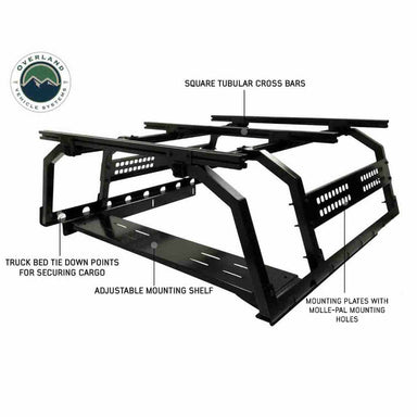 Image of the black OVS Discovery Rack, highlighting its square tubular crossbars, adjustable mounting shelf, truck bed tie-down points, and mounting plates with MOLLE-PAL mounting holes, shown on a white background
