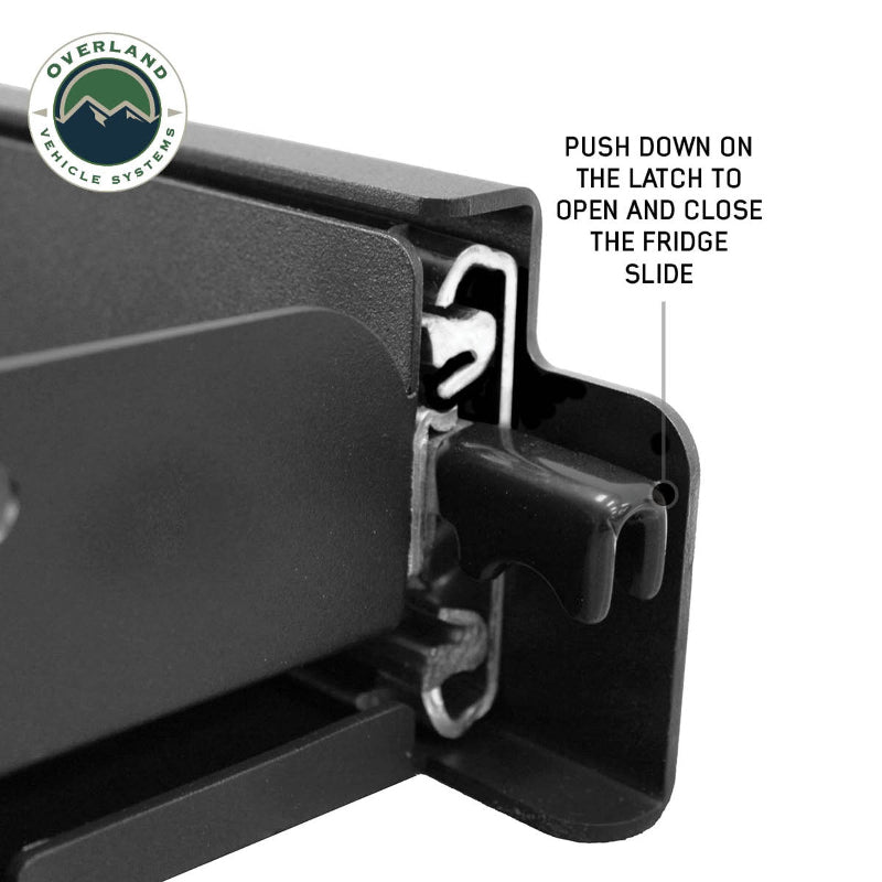 Image of a close-up view of the latch mechanism on an OVS refrigerator slide, with text explaining "PUSH DOWN ON THE LATCH TO OPEN AND CLOSE THE FRIDGE SLIDE". This detailed shot illustrates the simple and effective operation of the slide's locking system, making it easy for users to understand its functionalit