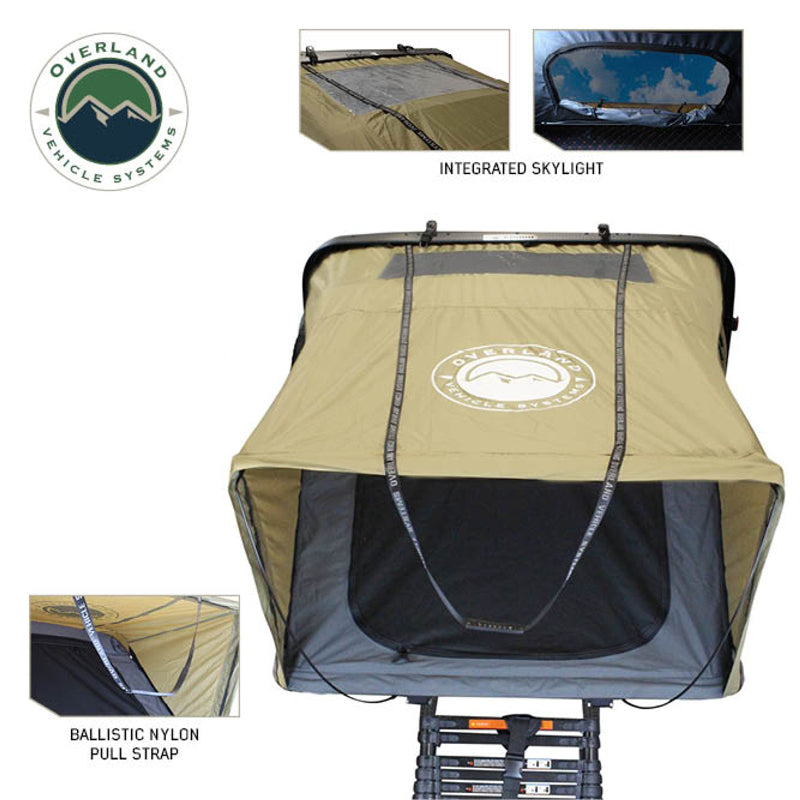 Image of Bundu HD Series roof top tent with integrated skylight, beige fabric with black underside, ballistic nylon pull strap, side view showing clear sky through the skylight, and mounted on a roof rack