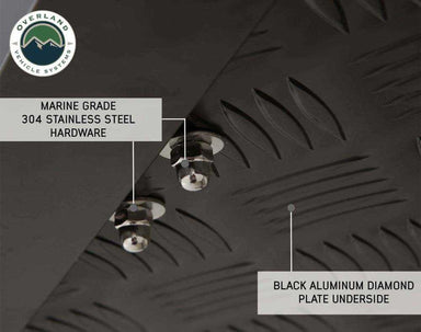 An image showing a close-up of the underside of a Bushveld Hard Shell Roof Top Tent, highlighting "MARINE GRADE 304 STAINLESS STEEL HARDWARE" and the "BLACK ALUMINUM DIAMOND PLATE UNDERSIDE" on a dark background