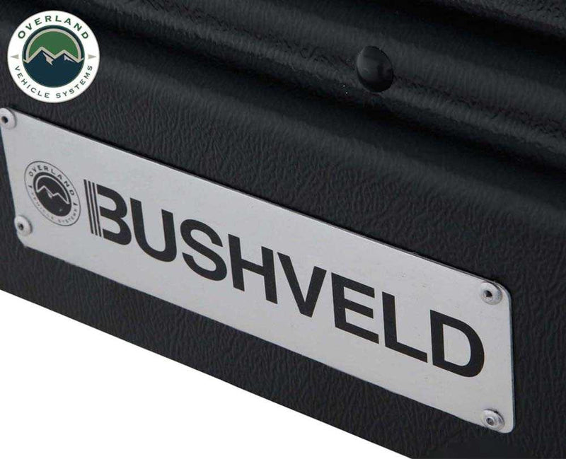 An image of a close-up, angled view of a silver "BUSHVELD" brand plate attached to a black textured surface