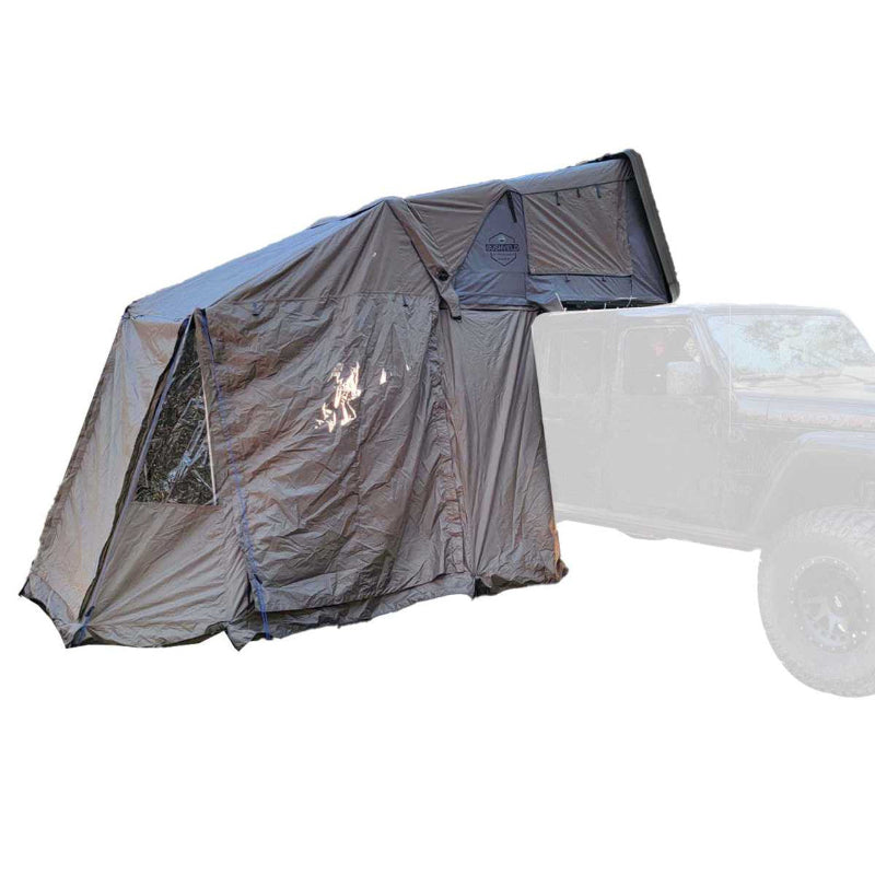 Image of an OVS Overland Vehicle Systems Bushveld tent fully deployed, showcasing a side room extension. The tent is mounted on top of an off-road vehicle, and the entire setup is shown against a white background