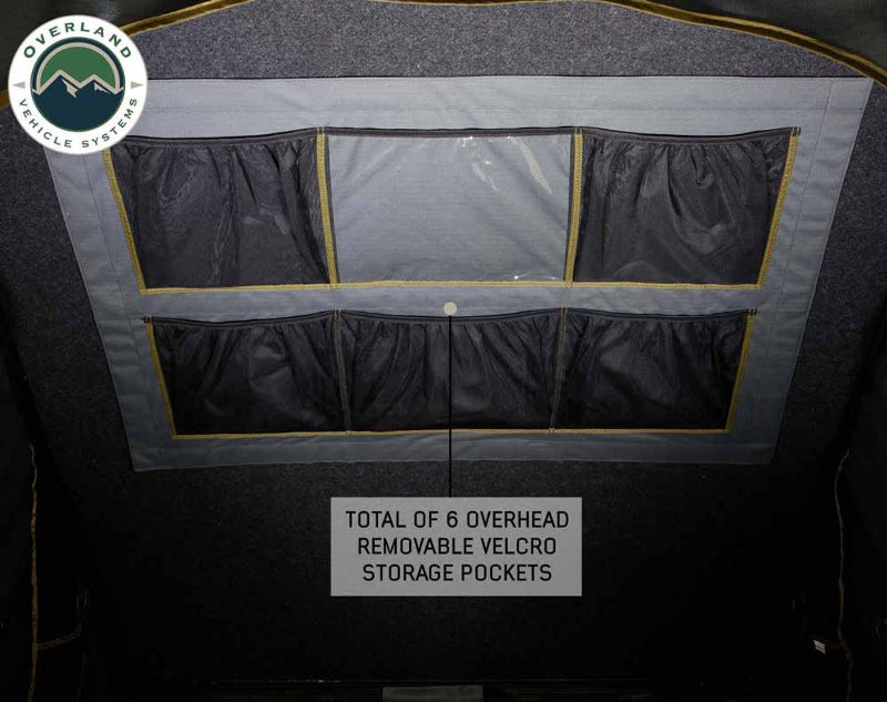 Image of Mamba Clam Shell Roof Top Tent interior showing 6 overhead removable Velcro storage pockets, close-up view of the fabric and pockets on a dark background