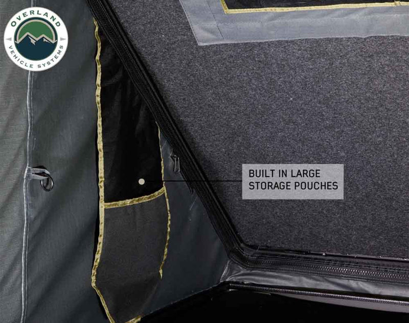 Image of Mamba Clam Shell Roof Top Tent showing built-in large storage pouches on the interior, close-up view of the pockets against the dark fabric background