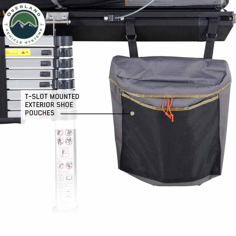 Image of Mamba Clam Shell Roof Top Tent showing T-slot mounted exterior shoe pouches attached to the ladder, with black mesh and grey fabric, close-up view on a white background