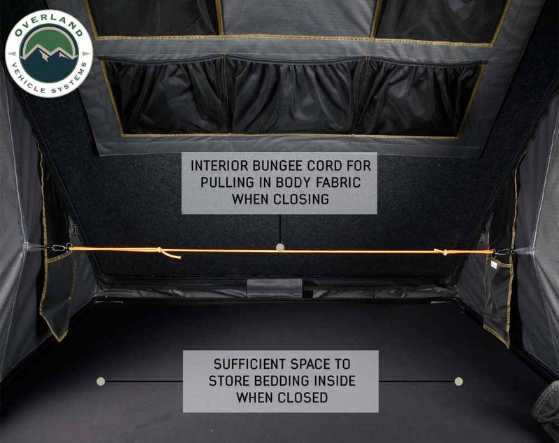 Image of Mamba Clam Shell Roof Top Tent interior, showing the interior bungee cord for pulling in body fabric when closing, with sufficient space to store bedding inside when closed, close-up view on a black background