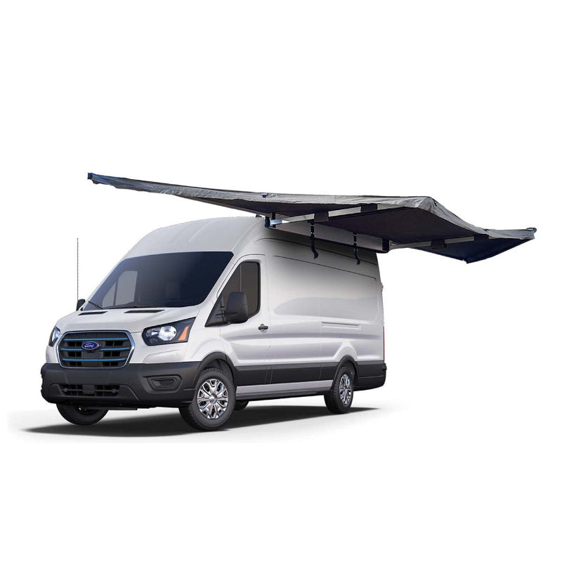 Image of the OVS Nomadic 180 Awning fully deployed on a white Ford van, dark grey fabric with a black underside, angled front and side view on a white background