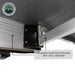 Image of a close-up of the aluminum frame box extrusion and steel hardware of an Overland Vehicle Systems 270-degree awning. The awning is partially open, showing a black pivoting bracket and the underside of the dark awning fabric