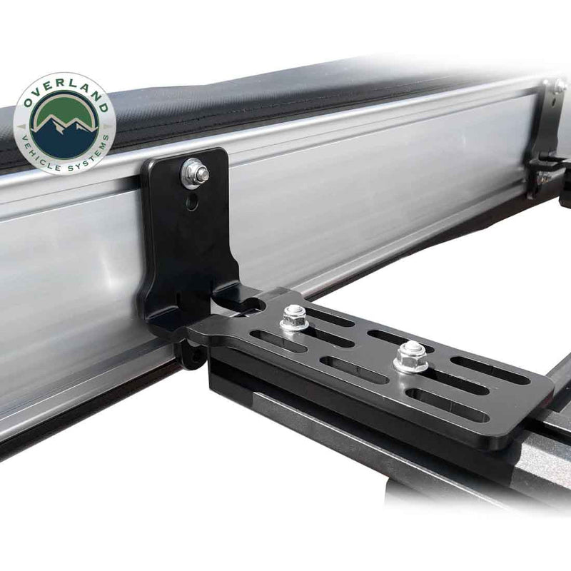 Image of a close-up of the black mounting bracket for an Overland Vehicle Systems 270-degree awning. The aluminum awning casing is shown attached to a roof rack, highlighting the heavy-duty bracket with its multiple adjustment slots and bolts