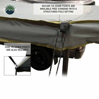 Image of a Peregrine Awning detailing its secure tie-down points and free-standing structured pole setting. The grey fabric with a green trim shows a close-up of the straps and ropes used for securing the awning, with text overlays highlighting these features